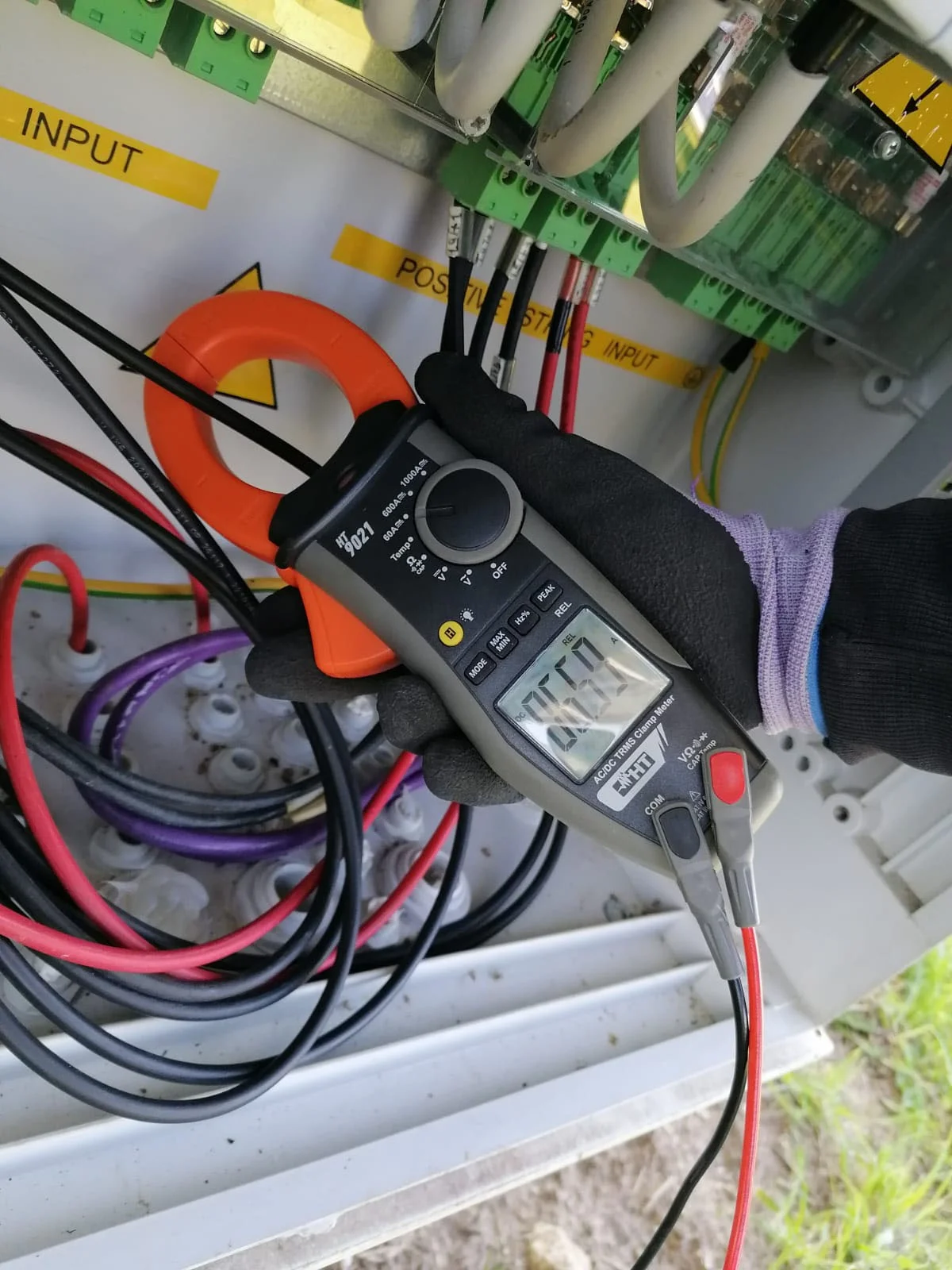 Tecnico durante la verifica strumentale di un inverter su un impianto fotovoltaico industriale